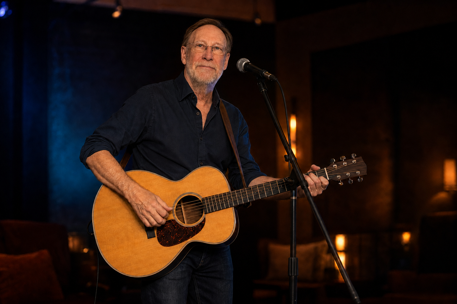 Lee Madden smiling and performing live with acoustic guitar
